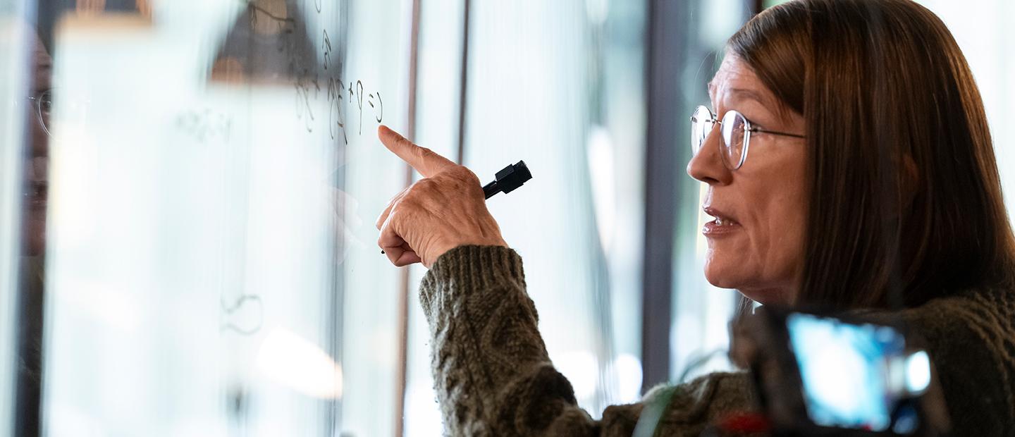 A woman writing on a white board